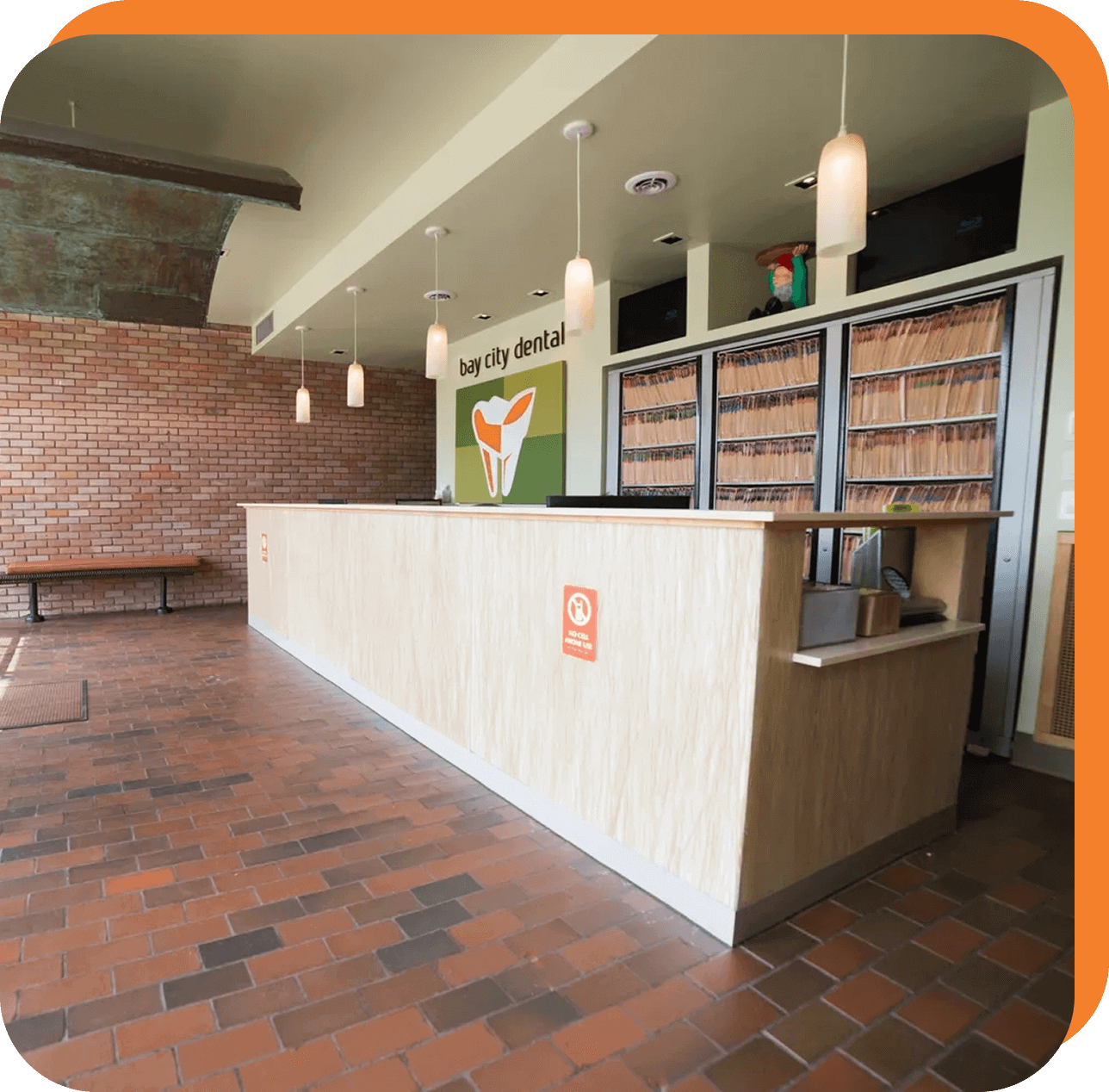 Dental office reception with brick wall decor.