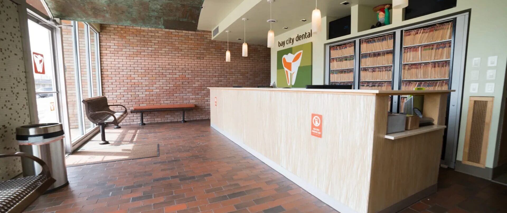 Dental office reception with brick wall.