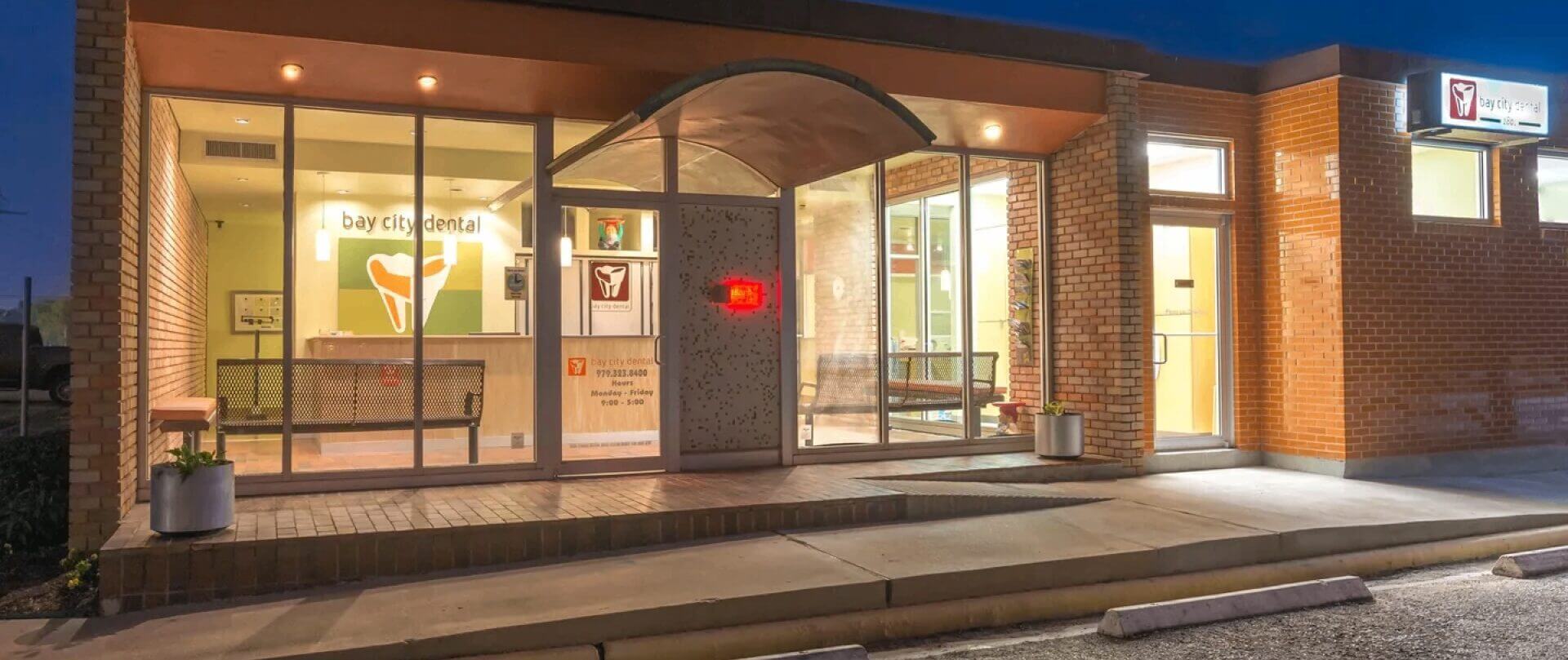 Dental clinic exterior with illuminated signage.