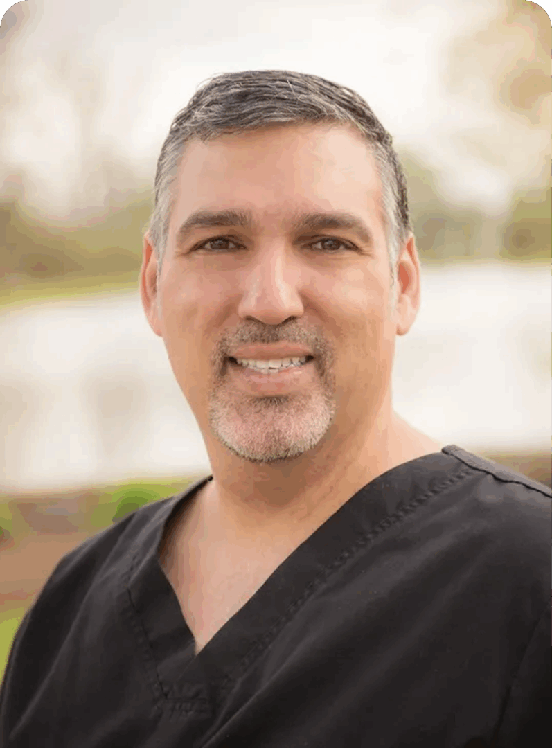 Smiling man in casual black shirt outdoors.