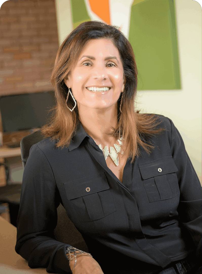 Smiling woman in a black blouse poses indoors.