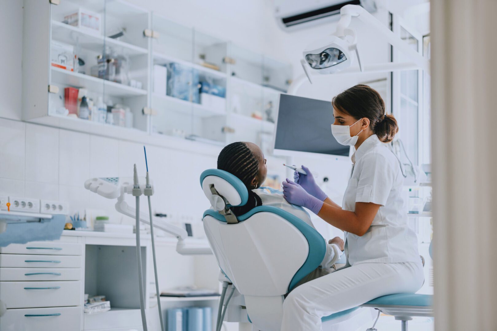 Dentist examining a young patient's teeth in a modern clinic.